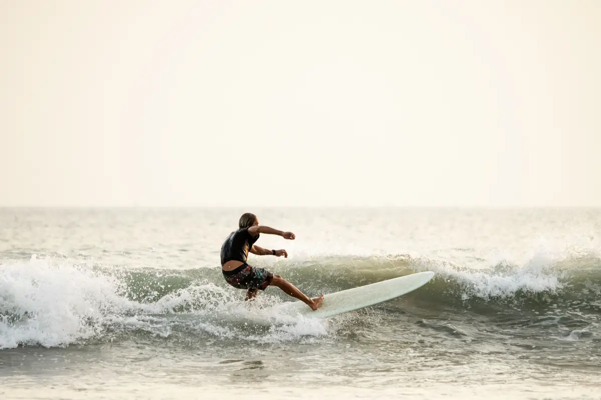A surfer carving a wave in the golden light off Mirissa